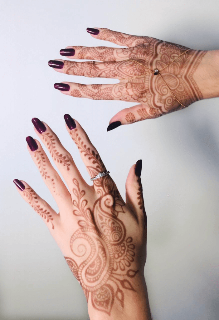 Mãos com tatuagem de henna ou mehandi.